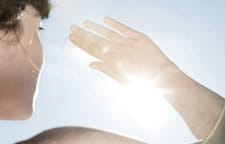 hình ảnh người phụ nữ đang đưa tay lên ngang mặt để che mặt khỏi ánh mặt trời