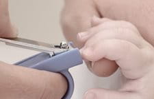Người mẹ đang cắt móng tay của em bé với đồ cắt móng tay