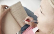 Người phụ nữ đang ghi gì đó lên sổ ghi chú của cô ấy