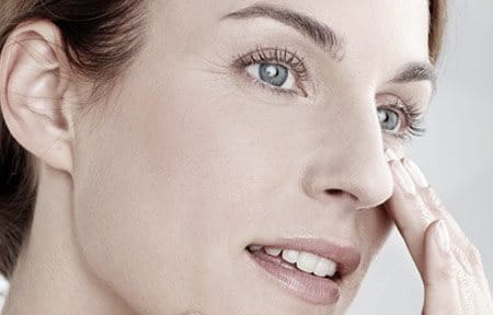 Hình ảnh người phụ nữ đang sờ cằm và mũi của cô ấy