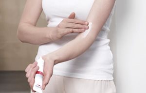 Người phụ nữ đang bôi sản phẩm Eucerin AtopiControl Care Cream lên khuỷu tay của cô ấy
