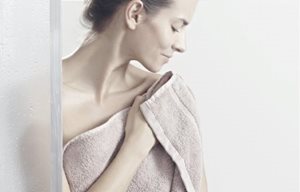 Người phụ nữ đang vỗ nhẹ làn da khô của cô ấy sau khi tắm