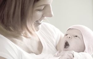 Người phụ nữ đang ẵm em bé mới sinh trên tay của cô ấy
