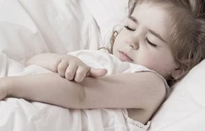 Bé gái nhỏ đang gãi khuỷu tay của cô ấy