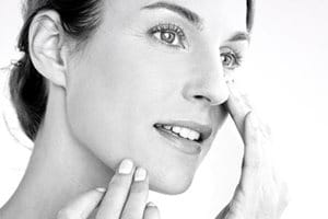 Hình ảnh người phụ nữ đang bôi kem lên má của cô ấy