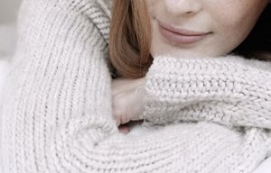 Người phụ nữ đang mặc chiếc áo chui đầu bằng cotton