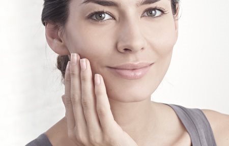 Hình ảnh cô gái bôi kem lên gương mặt