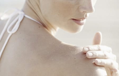 Hình ảnh người phụ nữ đang bôi kem lên vai phải của cô ấy